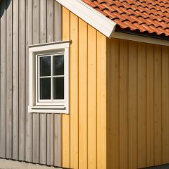 Ny träpanel på ett hus där halva väggen har fått grå ton av järnvitriol